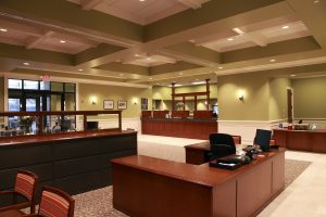 Extensive wood millwork defines the teller area. Wide wood wall and ceiling trim add emphasis to the traditional theme. Coffered wood ceilings also provide a measure of across-the-room acoustic control, to maintain confidentiality.