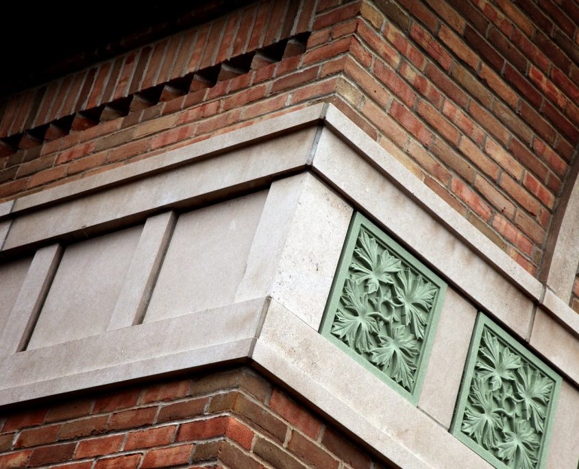 State Bank of The Lakes exterior oak leaf pattern green stone detail and brick & stone masonry.
